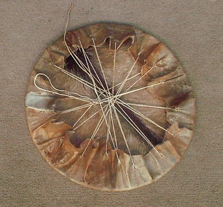 Drum head with string securing it