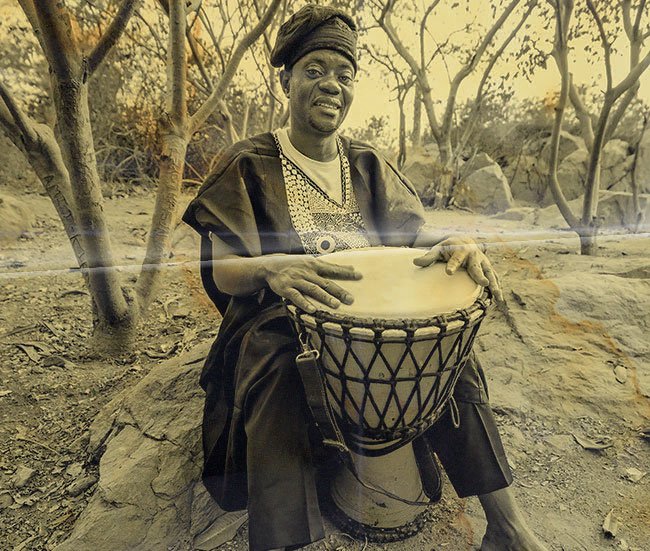 Old black and white photo of a djembe player