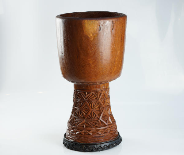 Professional studio photograph of a djembe wooden shell highlighting craftsmanship and wood quality